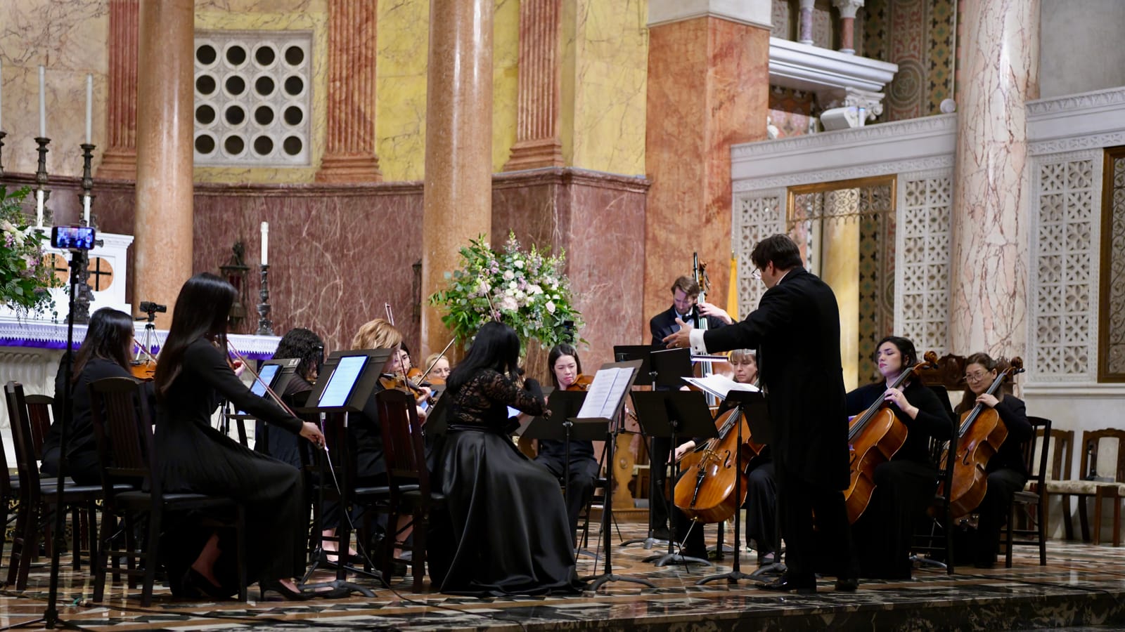 Director de orquesta guiando a un grupo de cuerdas durante un concierto