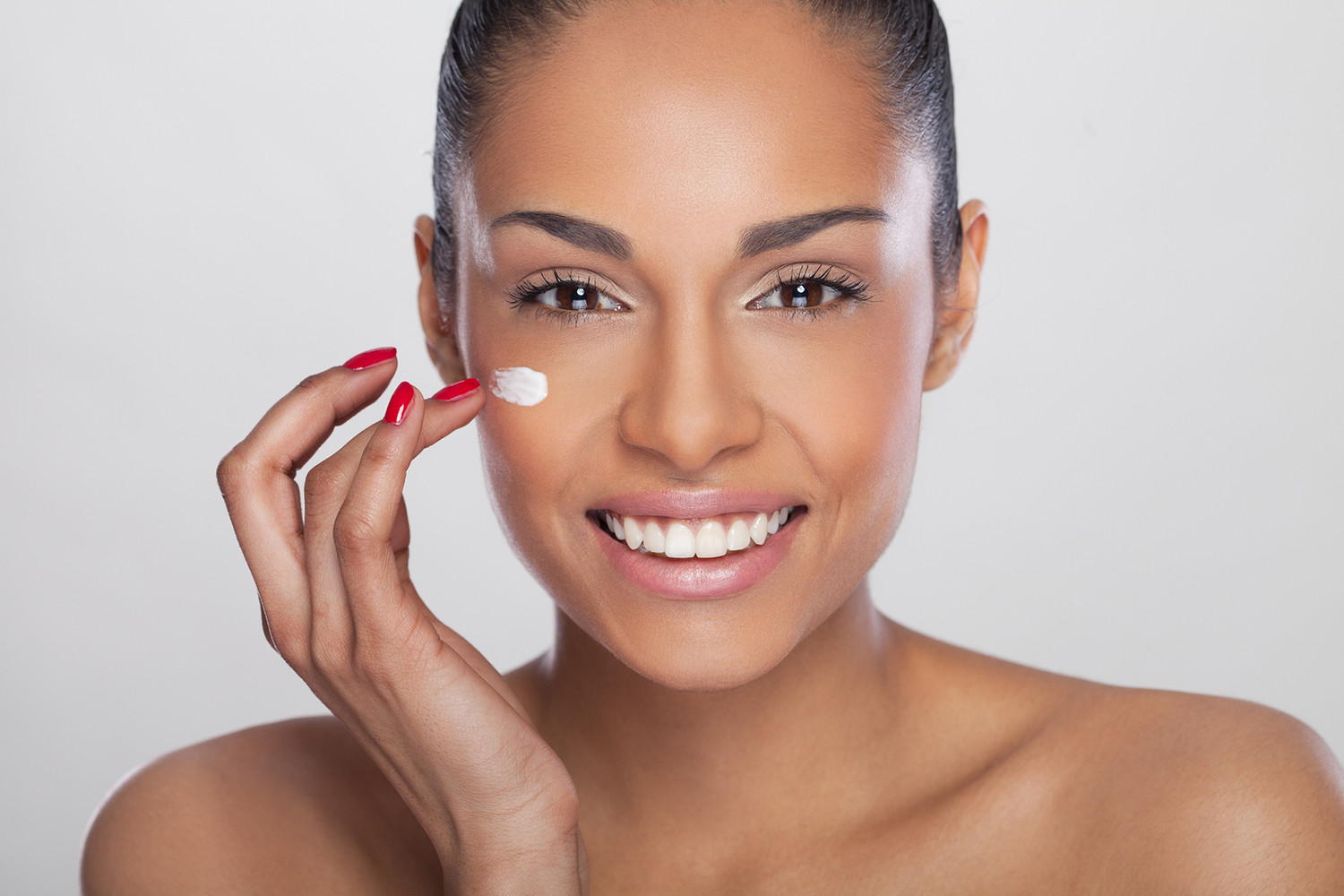 A client applying face cream.