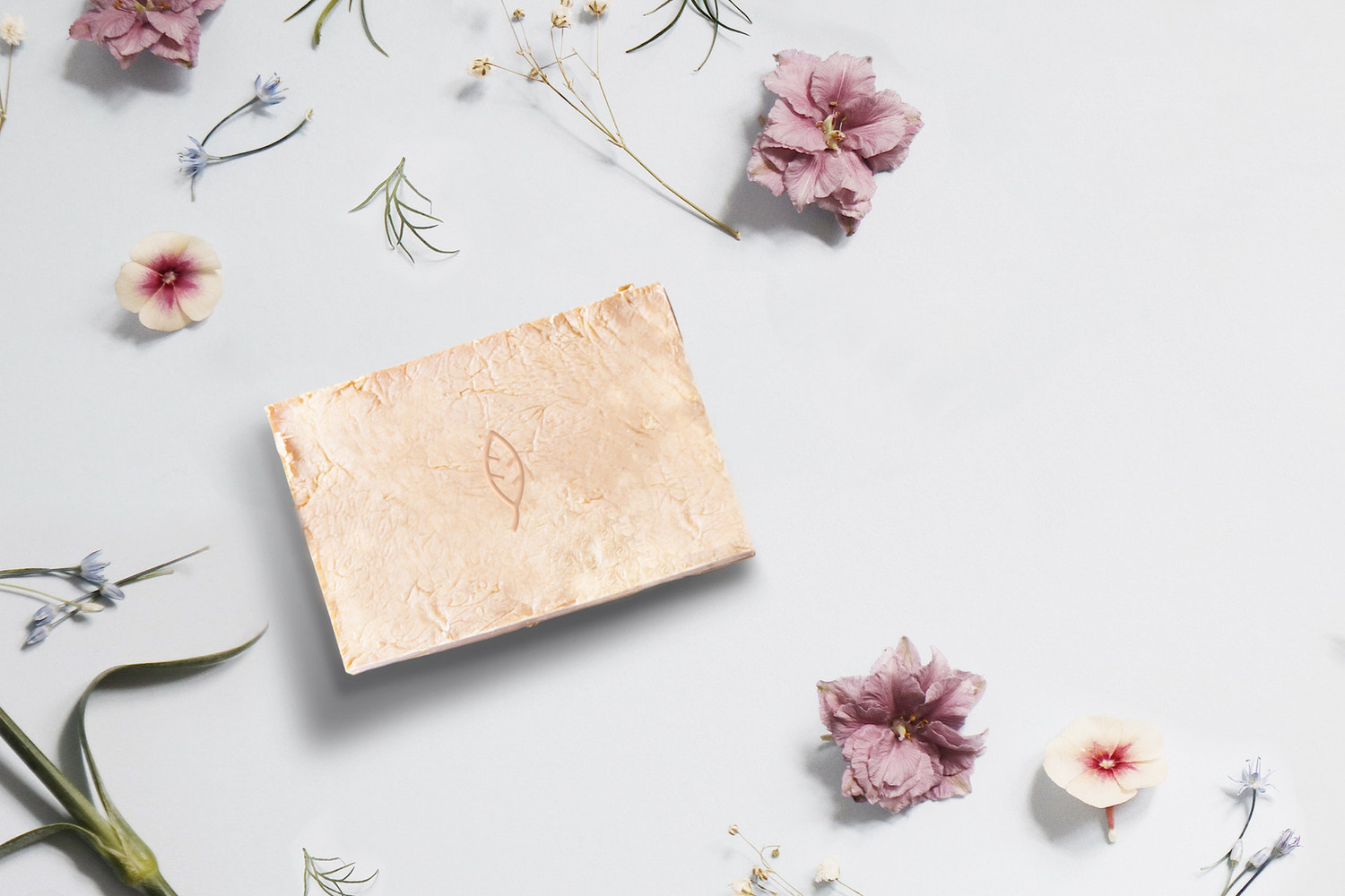 Handmade soap among dried flowers, part of the spa's visual style.